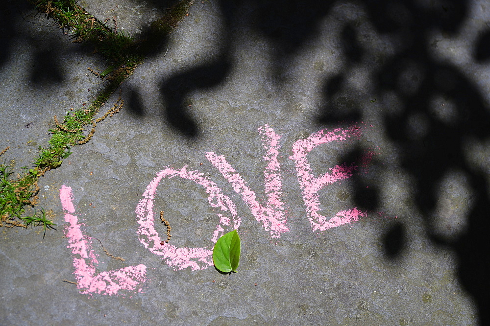 Word love written in chalk on city street