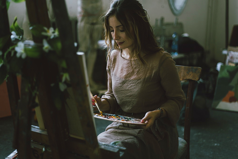 Woman painting on canvas in art studio