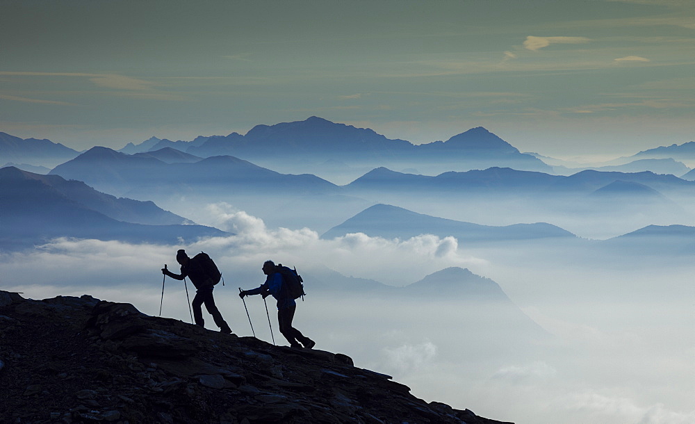 Italy, Piedmont, Alps, Monte Rosa, Silhouette of two climbers on mountain ridge