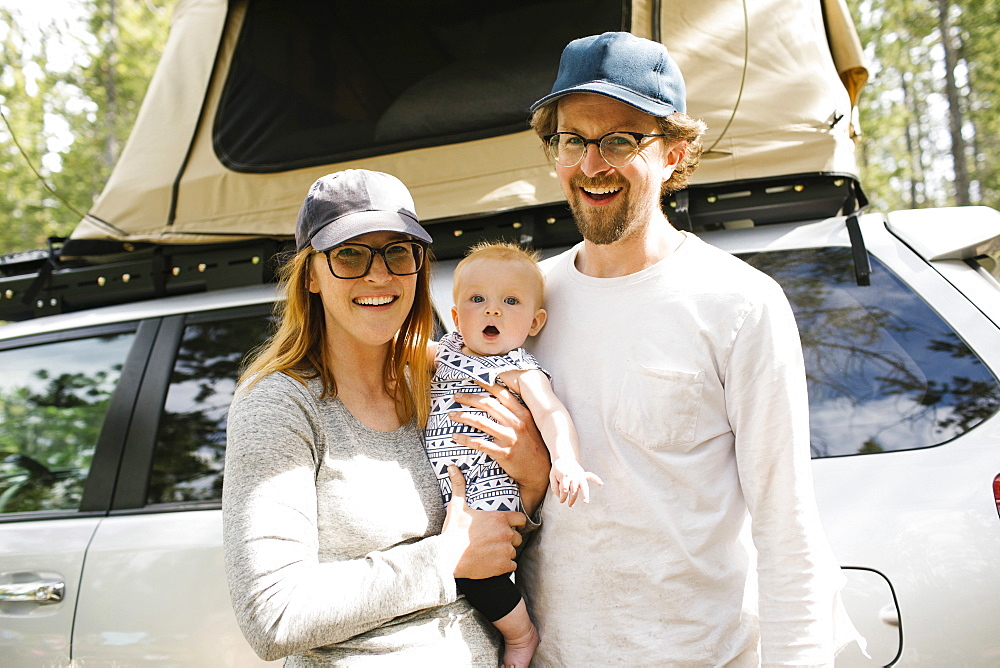 Portrait of parents with baby son (6-11 months) on camping in forest, Wasatch Cache National Forest