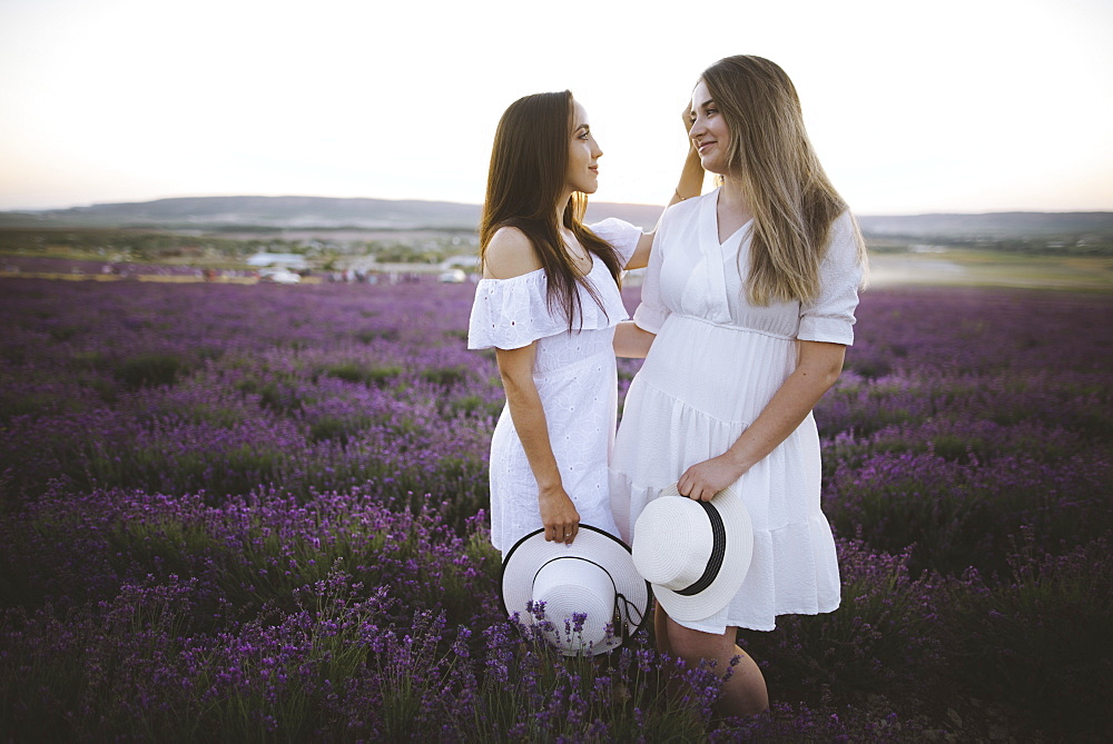 France, Young couple in white dresses standing in lavender field