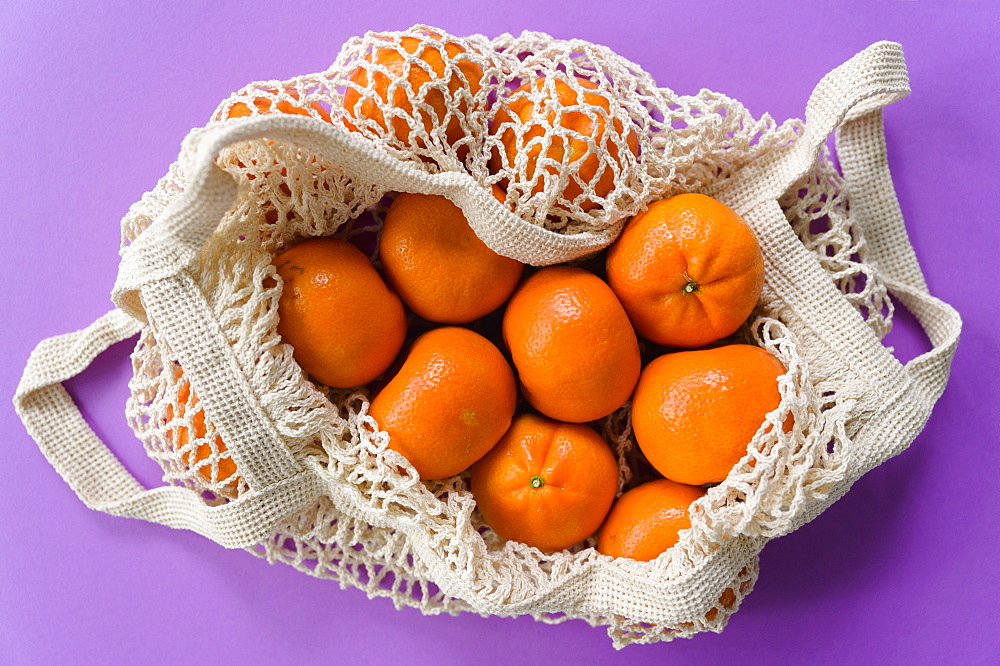 Bag of clementine on purple background