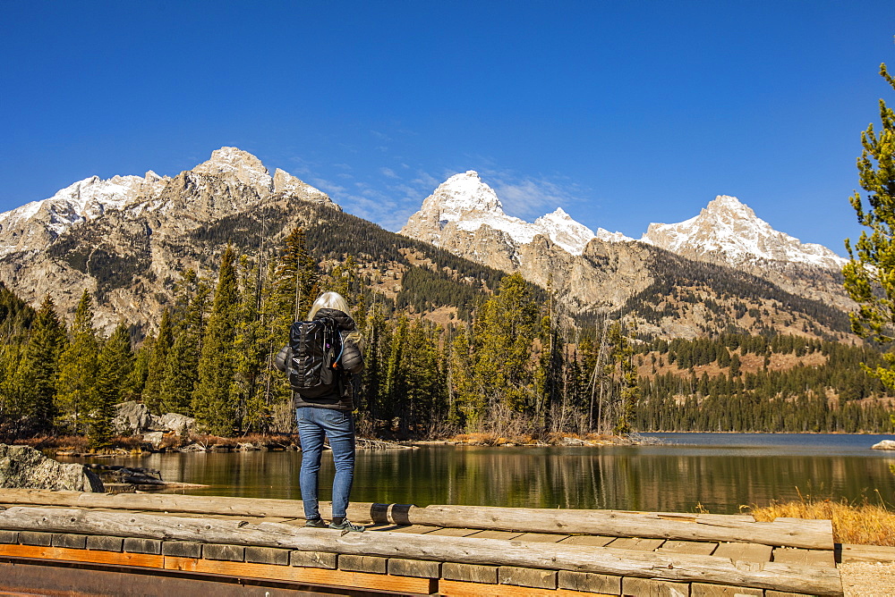 USA, Wyoming, Jackson, Grand Teton National Park, Senior woman standing by Taggart Lake in Grand Teton National Park