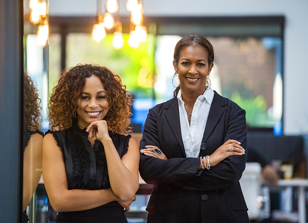 Portrait of two smiling businesswomen standing in office