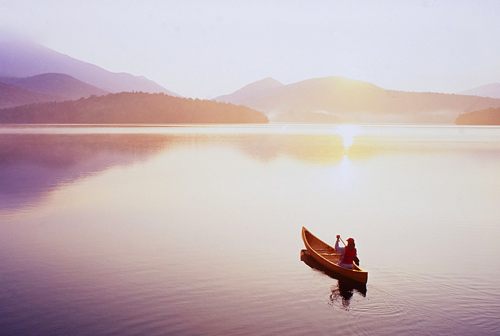 USA, New York, North Elba, Lake Placid, Woman canoeing on Lake Placid