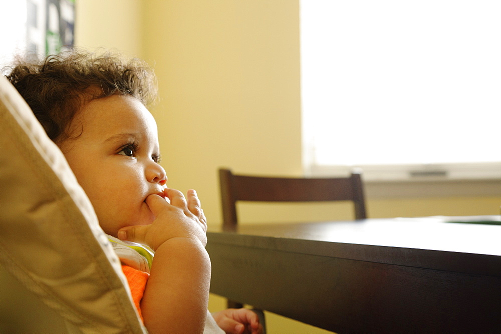 Mixed race baby sitting in high chair