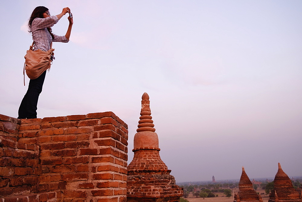 Woman taking photograph of view, Bagan Archaeological Zone, Buddhist temples, Mandalay, Myanmar