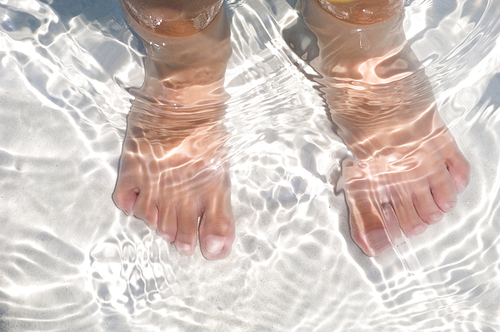 Child's feet standing in water