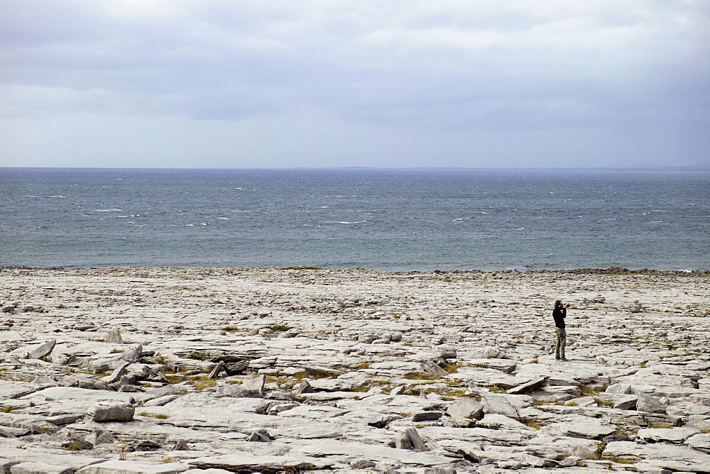 Man on rocky shore, The Burren, County Clare, Ireland