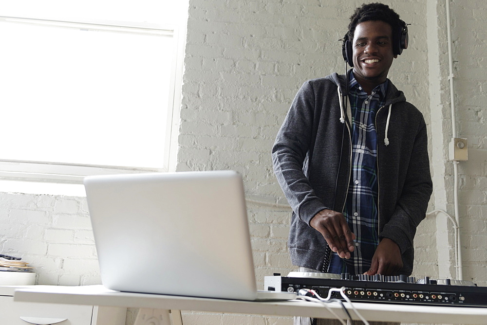 DJ using laptop and mixing desk