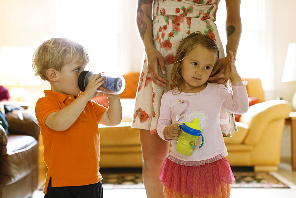 Toddler daughter next to mother sulking male toddler