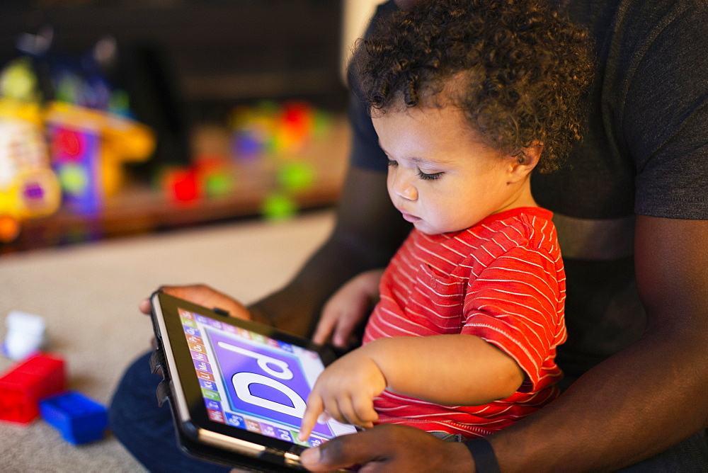 Father and son playing with digital tablet