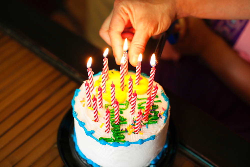 Hand putting candles into cake