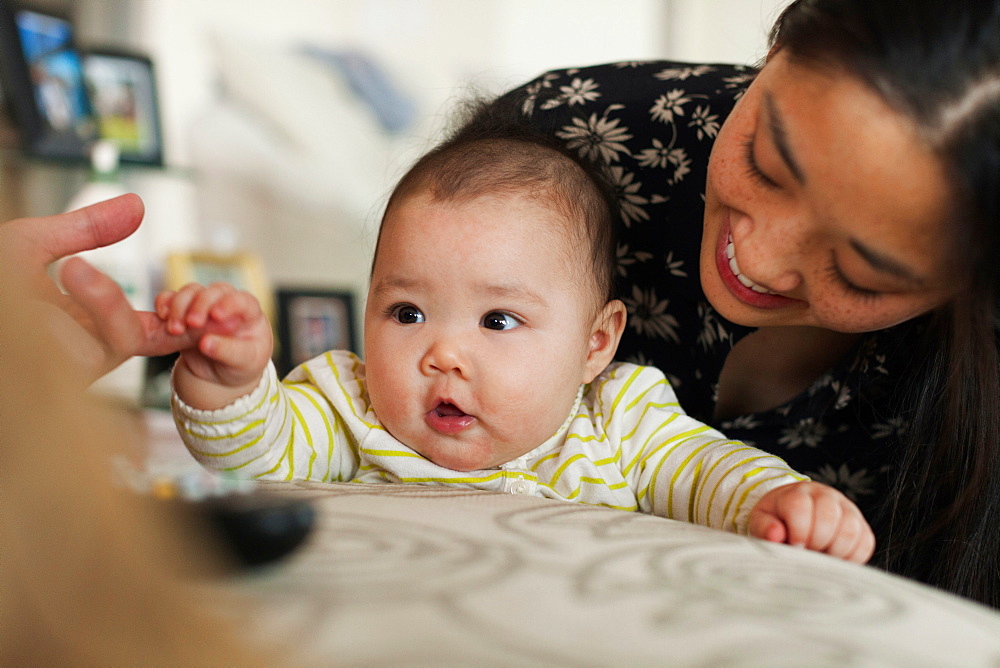 Close up of parents playing with baby daughter