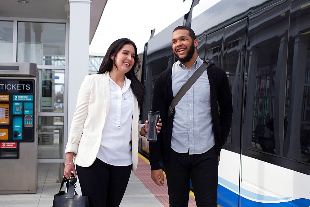 Young couple on platform with light train