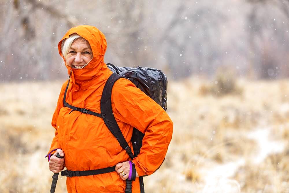 USA, Utah, Escalante, Woman hiking during snow flurry in Grand Staircase-Escalante National Monument