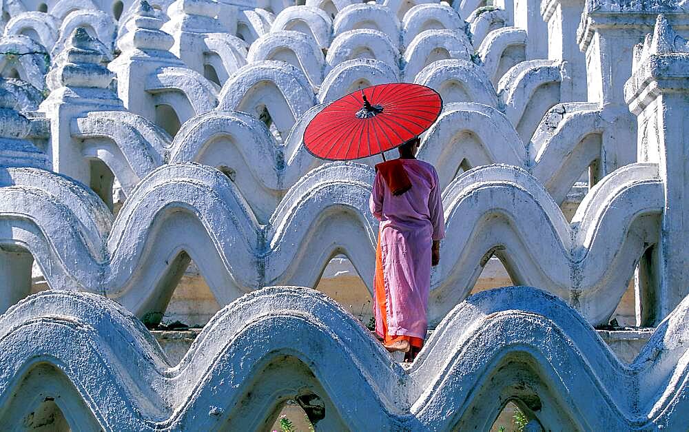 Myanmar, Mingun, Mandalay Division, Buddhist nun standing on white arches of Hsinbyume Pagoda