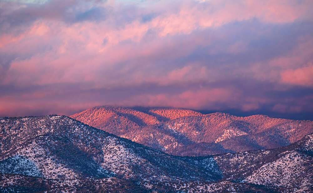 USA, New Mexico, Santa Fe, Colorful clouds at sunset over Sangre de Cristo Mountains