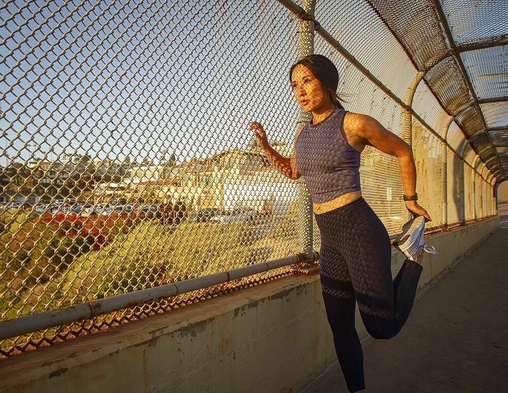 Athlete woman stretching at fence