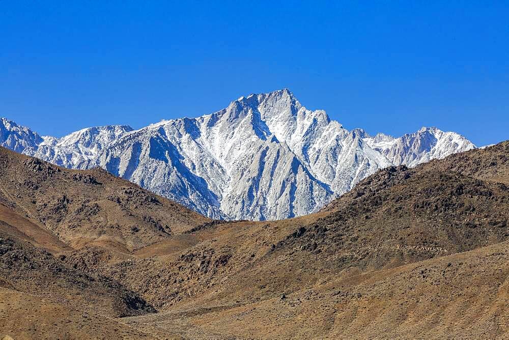 USA, California, Lone Pine, Snowcapped Mount Whitney with rocky hills in foreground