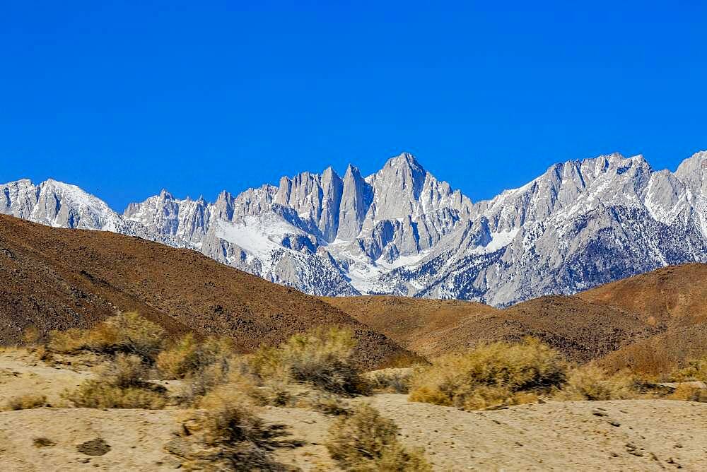 USA, California, Lone Pine, Snowcapped Mount Whitney with rocky hills in foreground