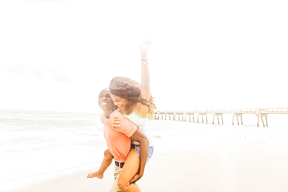 Young couple playing on beach, Jupiter, Florida