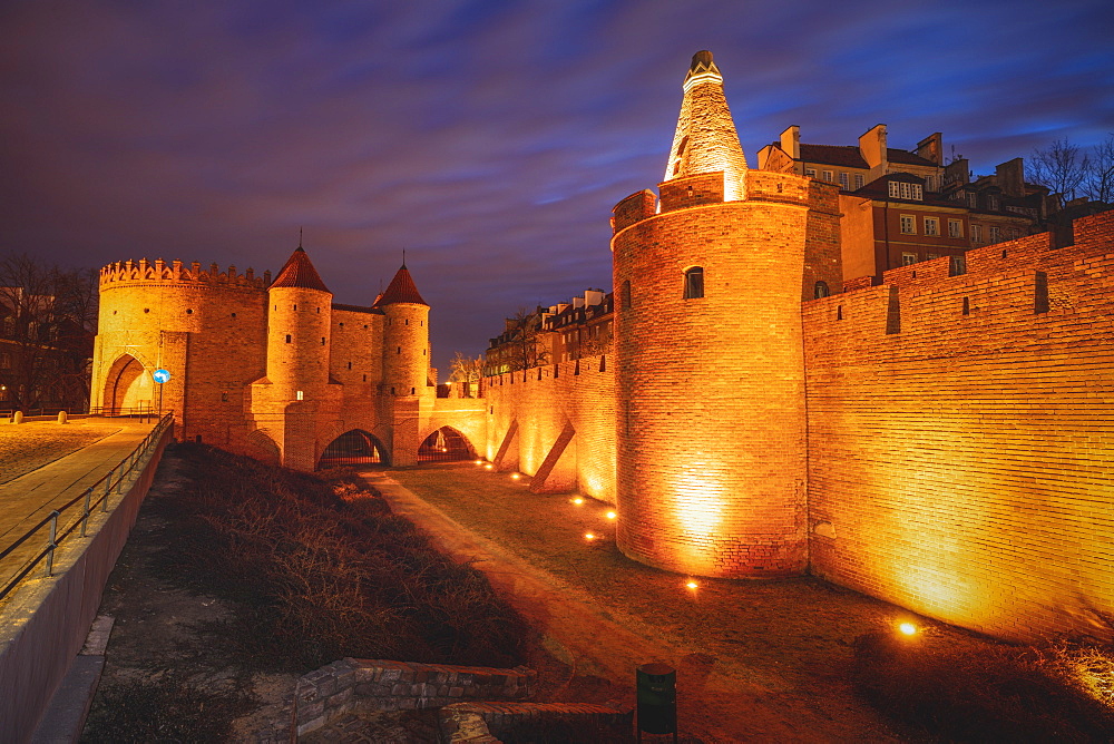 Poland, Masovia, Warsaw, Old City walls and barbican illuminated at night