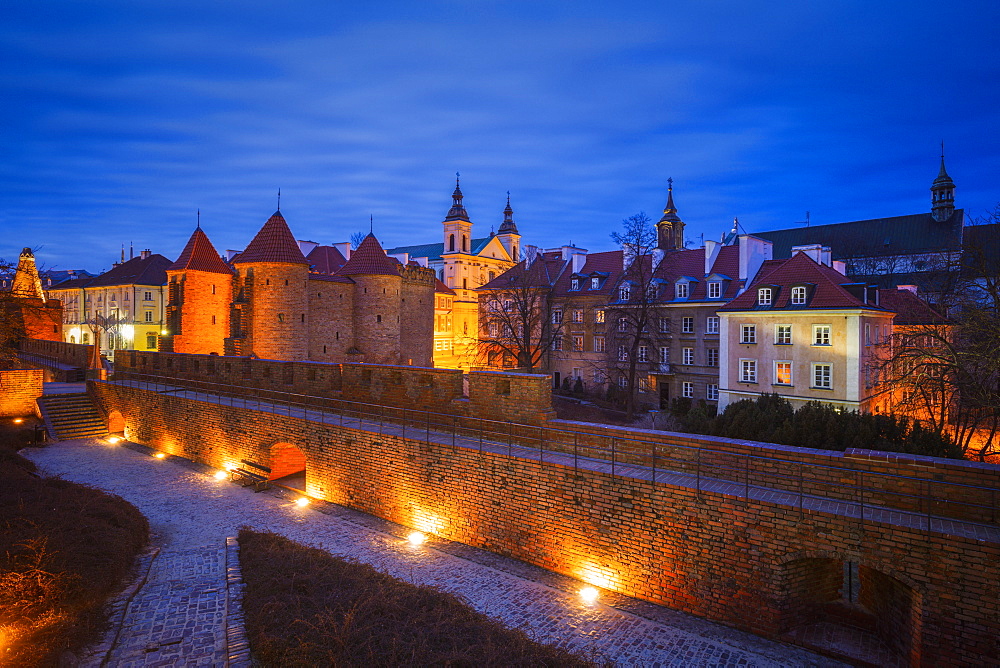 Poland, Masovia, Warsaw, Old City walls and barbican illuminated at night