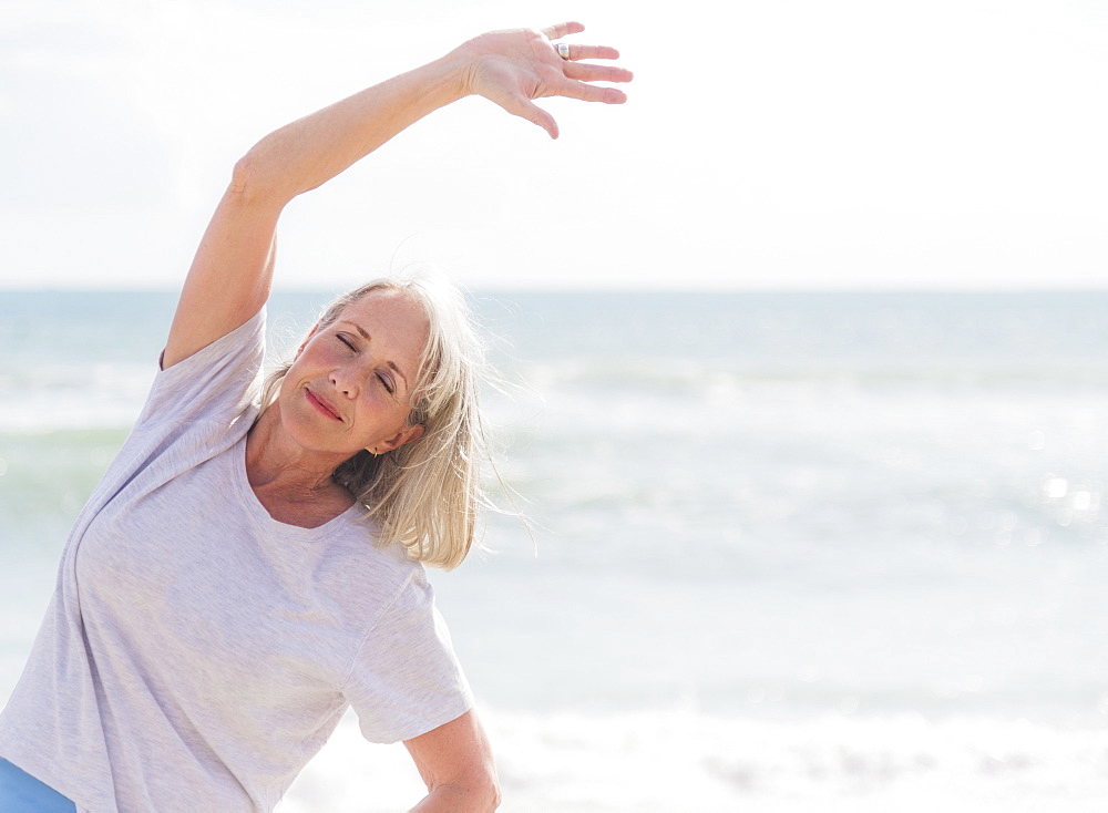 Senior woman exercising on beach