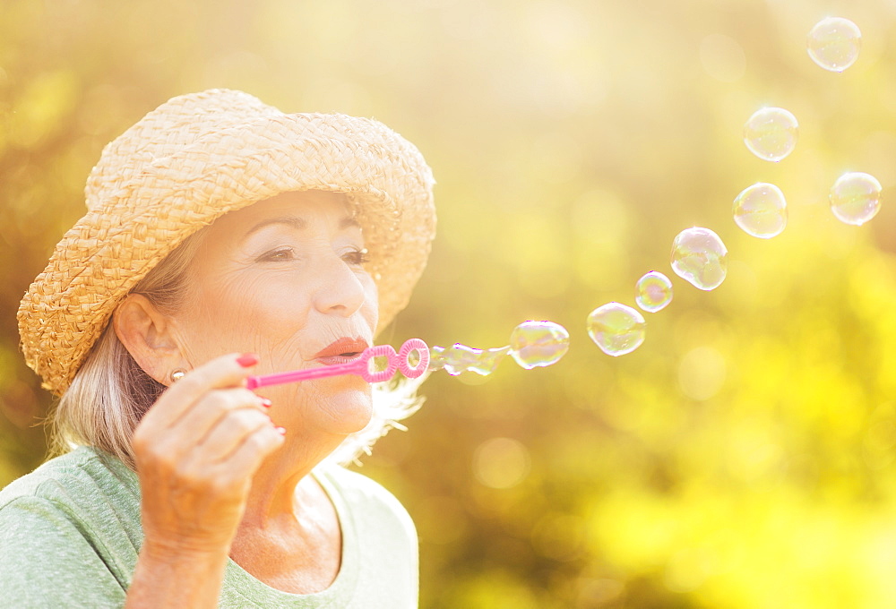 Senior woman blowing soap bubbles