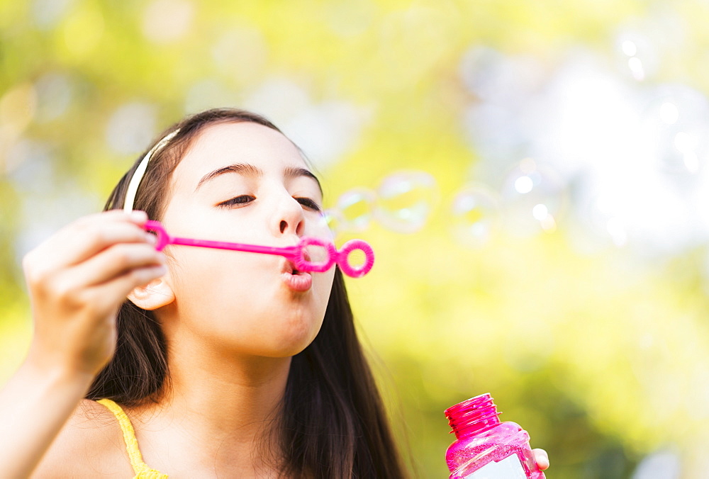 Portrait of girl (8-9) blowing bubbles