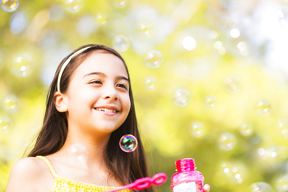 Portrait of girl (8-9) blowing bubbles