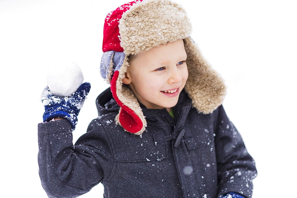 Boy (6-7) playing with snowball