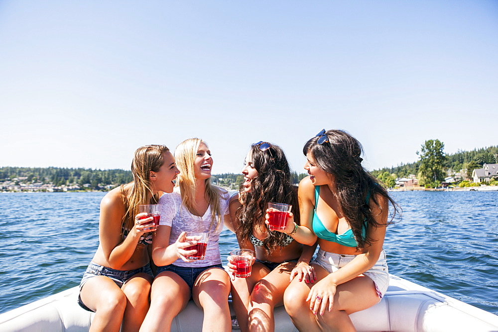 Young women having fun on motorboat, USA, Washington, Bellingham
