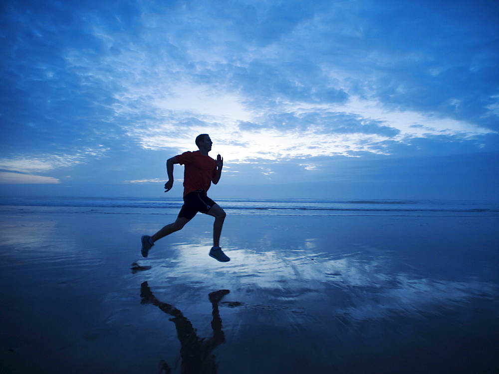Man running along beach, Rockaway Beach, Oregon