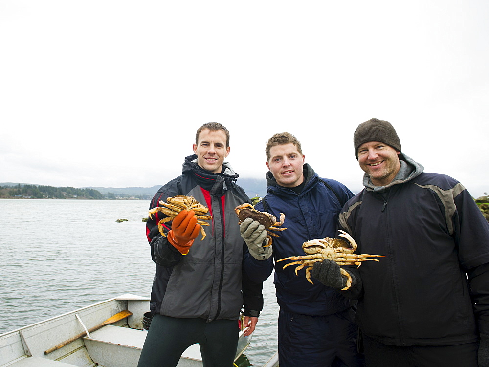 Portrait of people holding crabs, Rockaway Beach, Oregon