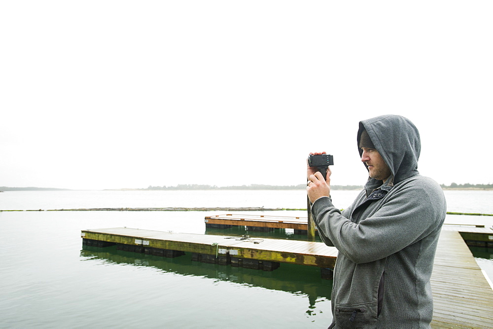 Side view of man photographing, Rockaway Beach, Oregon