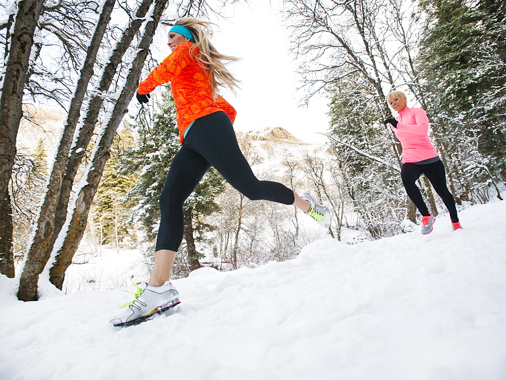 Two women jogging in winter forest, Salt Lake City, Utah USA