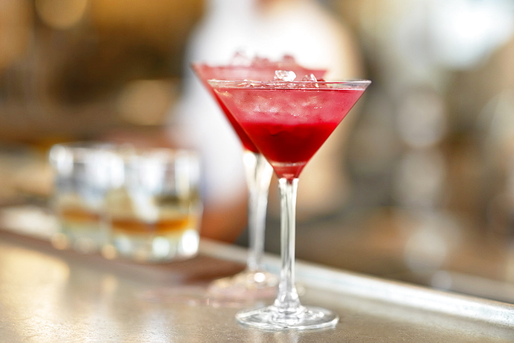 Two martini glasses standing on bar counter