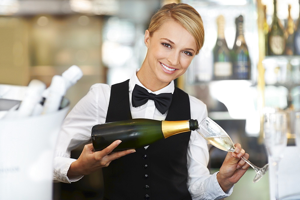 Waitress pouring champagne into champagne flute