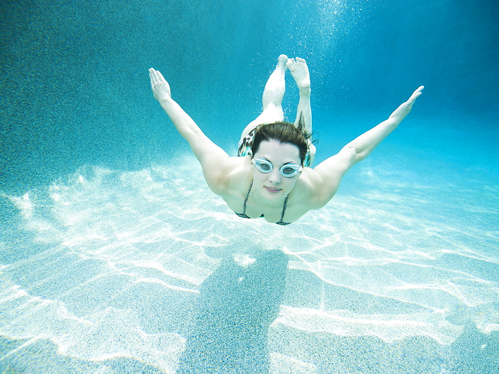 Young attractive woman diving in swimming pool