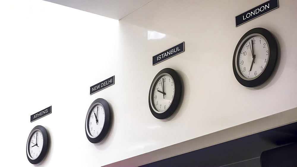 Time zone clocks in a row on wall