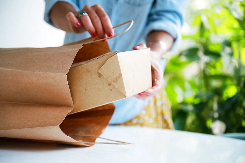 Close-up of woman unpacking take out food at home