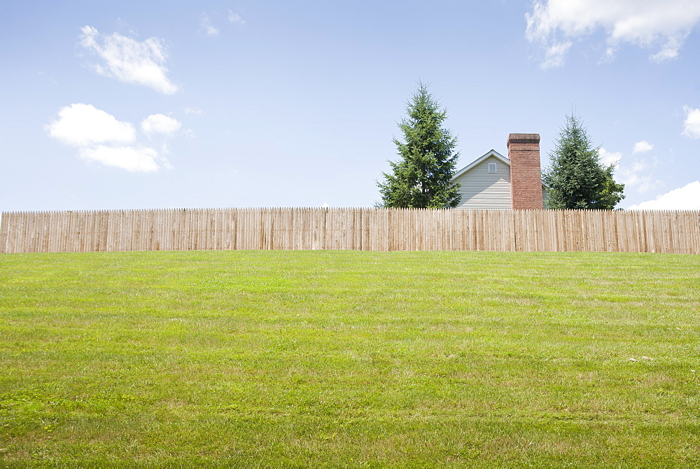 USA, New Jersey, Suburban house behind fence with lawn in foreground