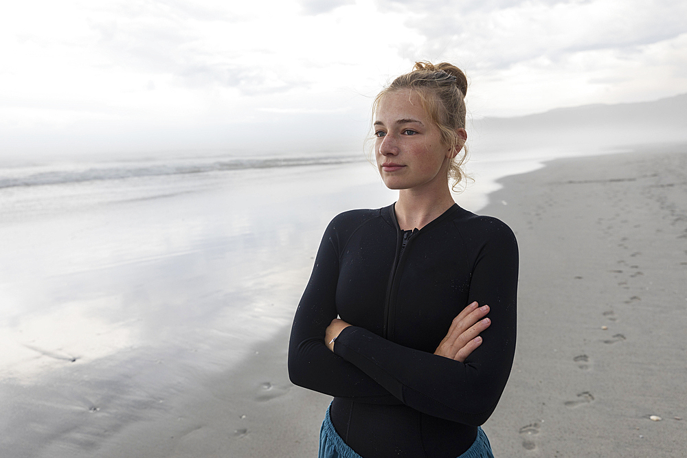 Portrait of girl (16-17) wearing wetsuit on Grotto Beach