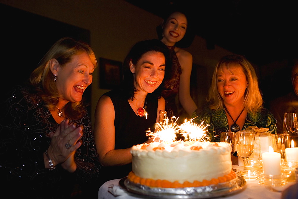 Group of friends celebrating birthday in restaurant