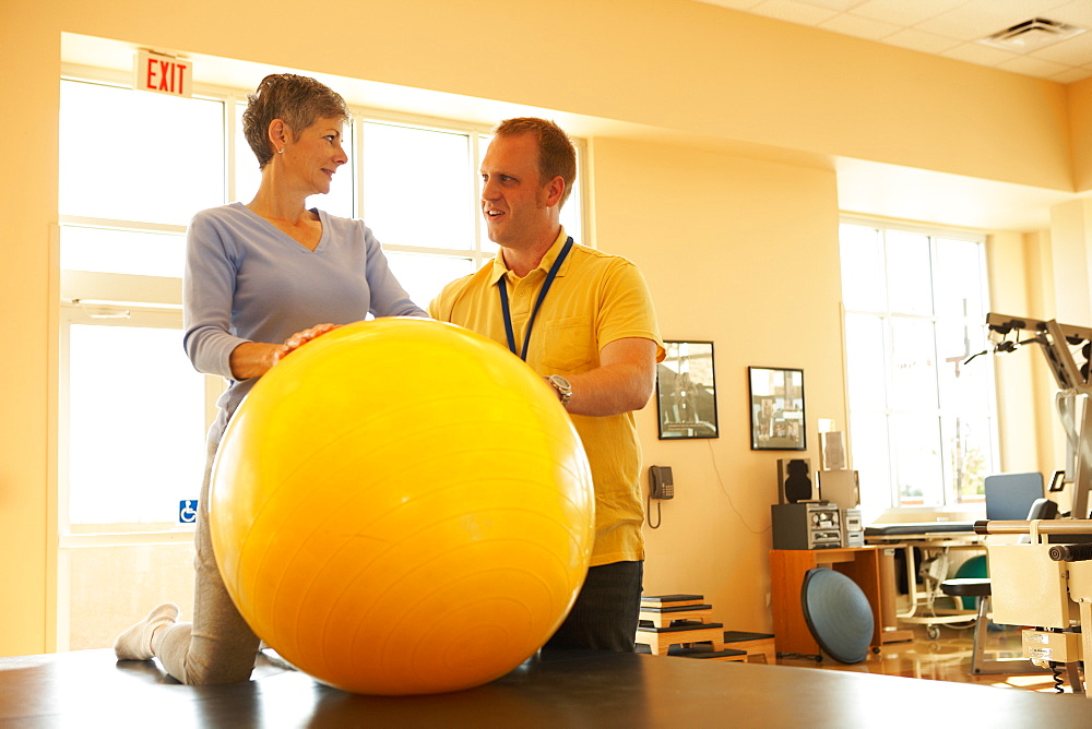 Physical therapist and patient with therapy ball