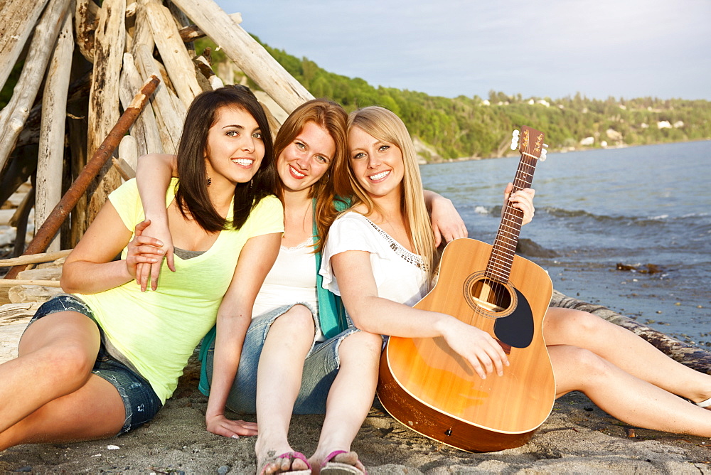 Portrait of three young women hanging out on beach