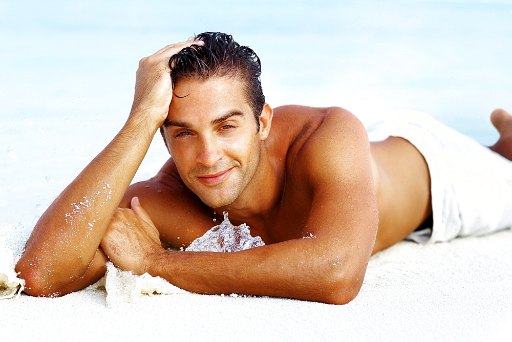 Smart young man relaxing on beach