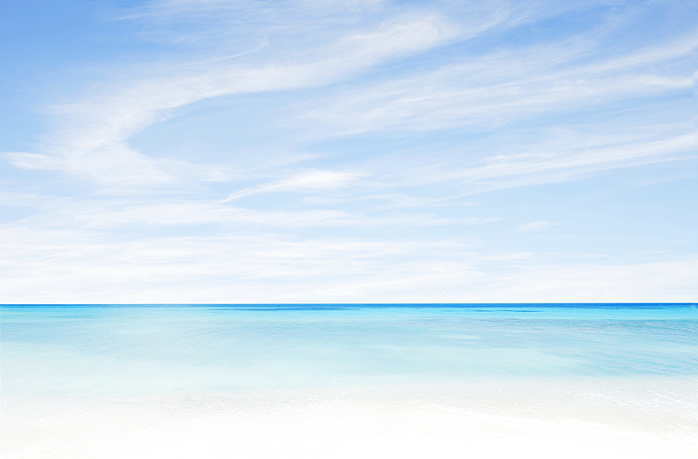 Wispy clouds above calm turquoise sea